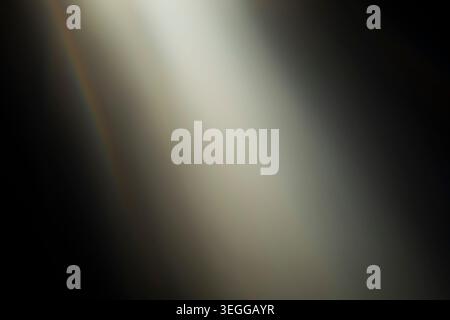 Cinematic soft warm light beam overlay passing through a dark background with subtle lens flare effects Stock Photo
