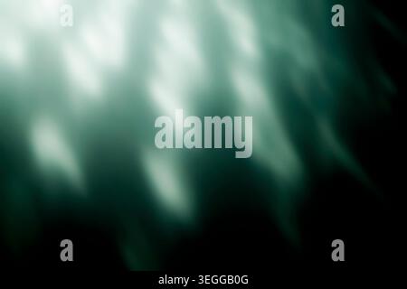 Abstract green light caustics and blurred glowing rays on black Stock Photo