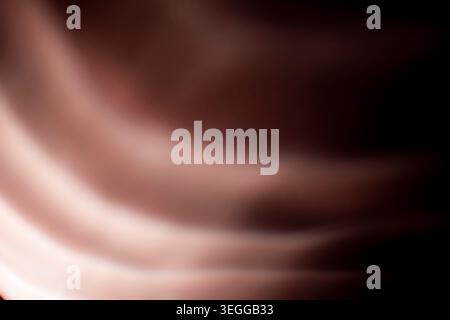 Smooth abstract dark pink folds resembling fabric waves on black background Stock Photo
