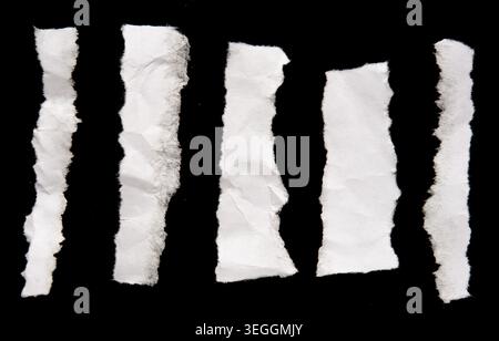 Ripped paper strips on black background Stock Photo