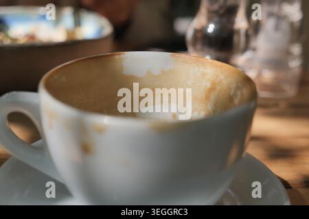 Coffee cup sits empty after a morning drink Stock Photo
