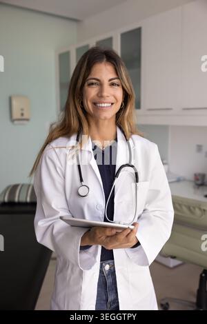 Portrait of young 35s Latina cardiologist woman holding digital tablet Stock Photo