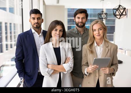 Confident business team standing in modern office Stock Photo