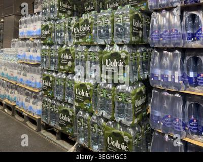 Mineral water bottled drinking water packaged in polyethylene terephthalate PET bottles stacked on pallets for storage, international Stock Photo