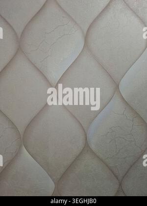 Beige wallpaper features an abstract wavy geometric design. The subtle texture adds depth to the surface, creating a modern look for interior spaces. Stock Photo