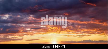 Panorama of a dramatic sunset sky with orange and pink clouds and light as a background or texture Stock Photo