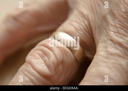Long marital status, senior's hand with a visible wedding ring. Stock Photo