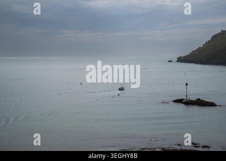 Salcombe to South Sands ferry as a small dot just beyond the Pound Stone on a calm spring day making it's way into South Sands with Splatcove point. Stock Photo
