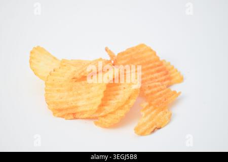 Crispy ridged potato chips seasoned with spicy barbecue powder isolated on a white background. Stock Photo