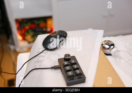 Black computer mouse and custom keypad macro pad rest on white surface desk creating calm practical setup for focused productivity and efficient workf Stock Photo