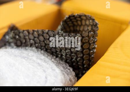 Protective bubble wrap packaging material inside yellow cardboard box ready for secure shipment feeling safe and carefully prepared for safe delivery Stock Photo