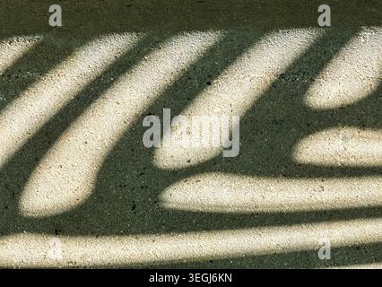 Abstract Shadow Patterns on Sunlit Concrete Surface Creating Organic Zebra-Like Stripes Stock Photo