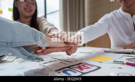 Asian business team showing teamwork and unity in office for project success. Stock Photo