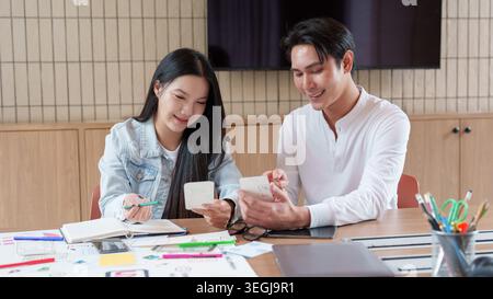 Asian UX UI design team collaborating on mobile app interface in office Stock Photo