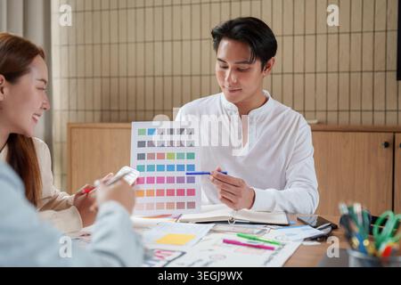 Asian design team collaborating on color palette for UX UI project in office Stock Photo