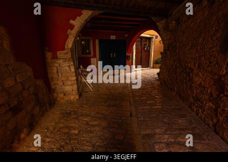 Stone archway corridor with white chairs and dark blue door in the old town of Rovinj, Croatia. Stock Photo