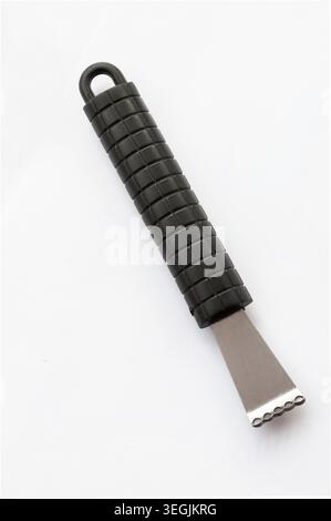 Stainless steel citrus zester and channel knife with textured black handle, photographed isolated on white background, modern kitchen utensil used for Stock Photo