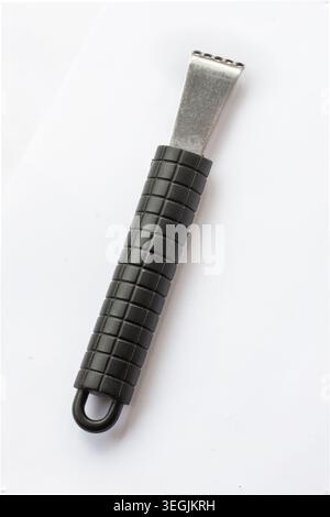 Stainless steel citrus zester and channel knife with textured black handle, photographed isolated on white background, modern kitchen utensil used for Stock Photo