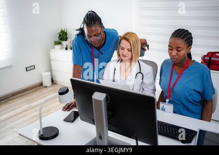 Medical team collaborating on computer healthcare information Stock Photo