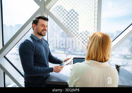 Business colleagues collaborating on digital tablet in modern office Stock Photo