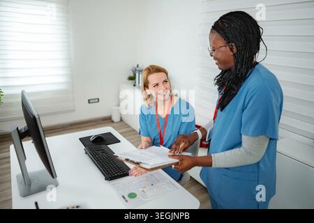 Nurses discussing patient files in hospital office Stock Photo