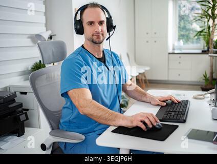Doctor wearing headset consulting online in clinic office Stock Photo