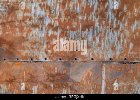 Close up photograph of weathered rusty sheet metal with visible screws and oxidized surface patterns Stock Photo