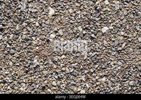 Close up photograph of coarse gravel and small stones on a rural gravel road surface Stock Photo