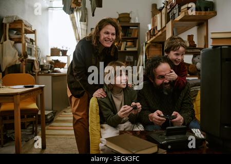 Family Playing Video Games Together at Home on Budget Lifestyle Stock Photo