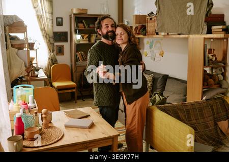 Middle Aged Couple Dancing at Home Despite Financial Hardship Stock Photo