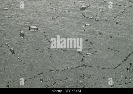 Slate stone surface with water drops, macro, top view. Stock Photo