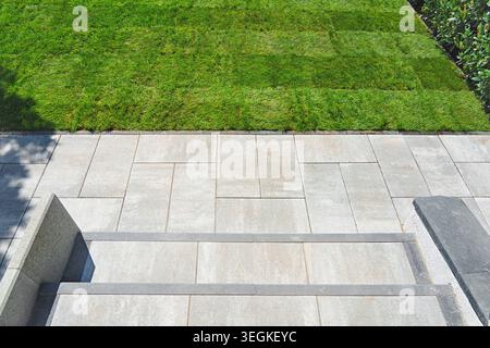 Gardening. Making a lawn from a roll. Green grass texture - well-groomed turf in the garden. View of the garden from above. Stock Photo