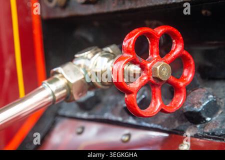 Wadebridge, Cornwall, England, June 2025, a close up view of a red painted valve tap on a vintage steam engine. Stock Photo