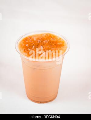 Iced milk tea with crushed ice top in a clear plastic cup against white background Stock Photo