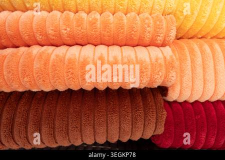 Ribbed plush fabric in yellow, apricot, brown and red with soft, warm texture and abstract striped lines, cozy domestic textile background perfect for Stock Photo