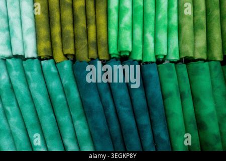 Fabric swatches arranged in rows displaying a gradient of colors from light to dark green, highlighting a textile collection with diverse patterns and Stock Photo