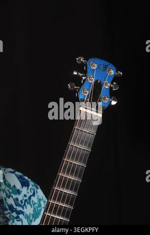 Close up of Modern Acoustic Guitar Headstock with Blue Sparkle Finish and Chrome Tuners on Black Background Stock Photo