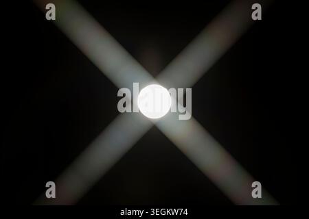 The sun with "X" shaped flares against the black sky Stock Photo