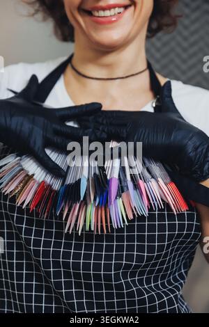 Smiling woman holds colorful nail polish samples Stock Photo