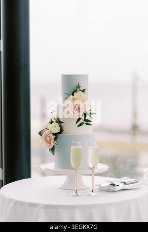 Sophisticated wedding setting showcasing delightful twolayer cake adorned with floral accents Stock Photo
