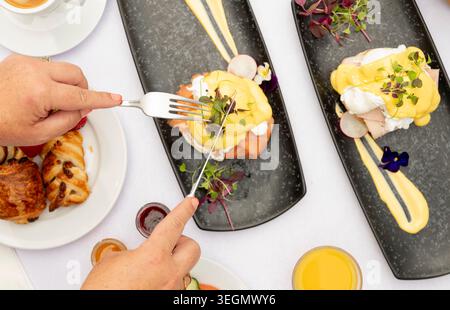 Delightful Brunch Spread With Eggs Benedict and Fresh Pastries Served in a Vibrant Setting Stock Photo