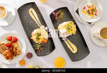Delicious Brunch Spread Featuring Eggs Benedict, Pastries, and Refreshing Drinks for a Sunny Day Stock Photo