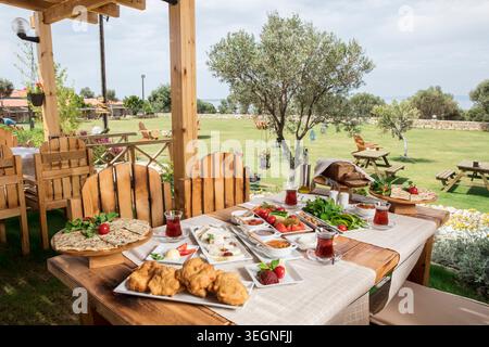 Rich Mediterranean Breakfast Served Outdoors, Abundant Traditional Turkish Breakfast with Fresh Bread, Cheese, Olives, Eggs and Seasonal Ingredients Stock Photo