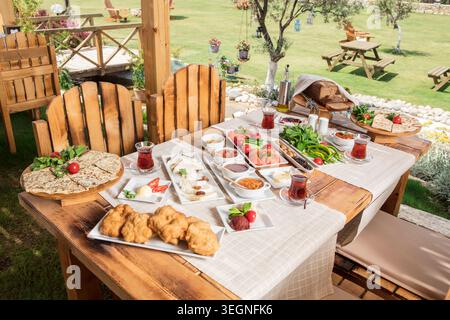 Rich Mediterranean Breakfast Served Outdoors, Abundant Traditional Turkish Breakfast with Fresh Bread, Cheese, Olives, Eggs and Seasonal Ingredients Stock Photo