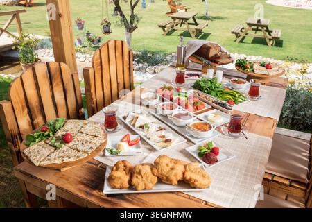 Rich Mediterranean Breakfast Served Outdoors, Abundant Traditional Turkish Breakfast with Fresh Bread, Cheese, Olives, Eggs and Seasonal Ingredients Stock Photo