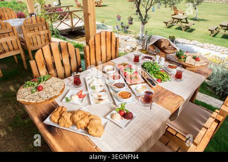 Rich Mediterranean Breakfast Served Outdoors, Abundant Traditional Turkish Breakfast with Fresh Bread, Cheese, Olives, Eggs and Seasonal Ingredients Stock Photo