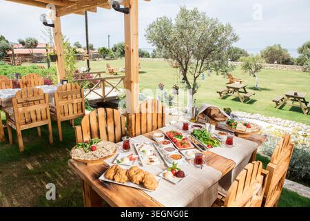 Rich Mediterranean Breakfast Served Outdoors, Abundant Traditional Turkish Breakfast with Fresh Bread, Cheese, Olives, Eggs and Seasonal Ingredients Stock Photo