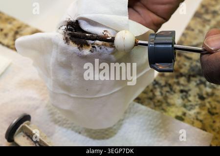 A black African-African man cleaning and repairing a clogged bathroom drain Stock Photo