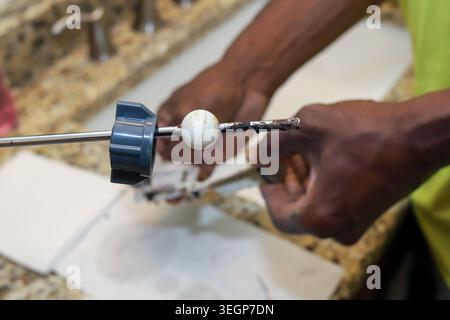A black African-African man cleaning and repairing a clogged bathroom drain Stock Photo