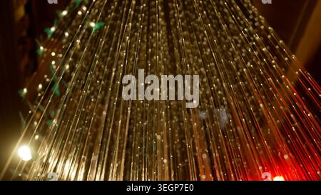 Fiber optic cables creating a vibrant digital network, transmitting data as glowing lines and light particles on a dark background Stock Photo